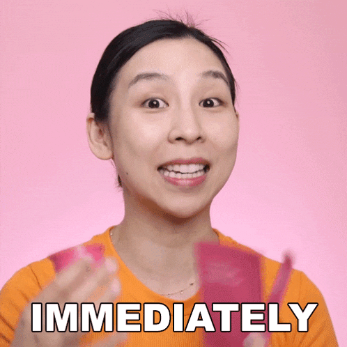 a woman in an orange shirt is holding a pink object and says immediately