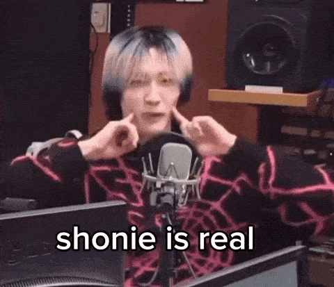 a man is sitting in front of a microphone with the words " shonie is real " written on the bottom
