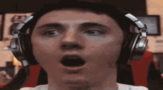 a man wearing headphones is making a funny face with his mouth open .