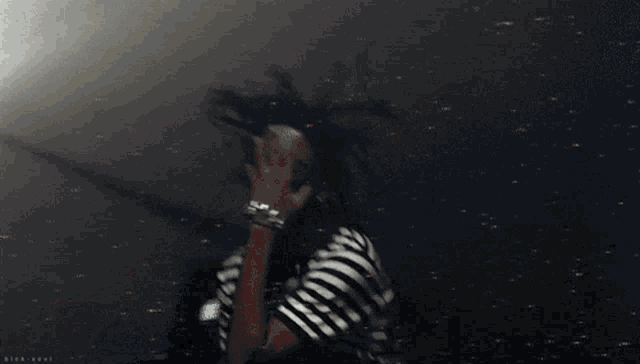 a person covering their face with their hand in a blurry image