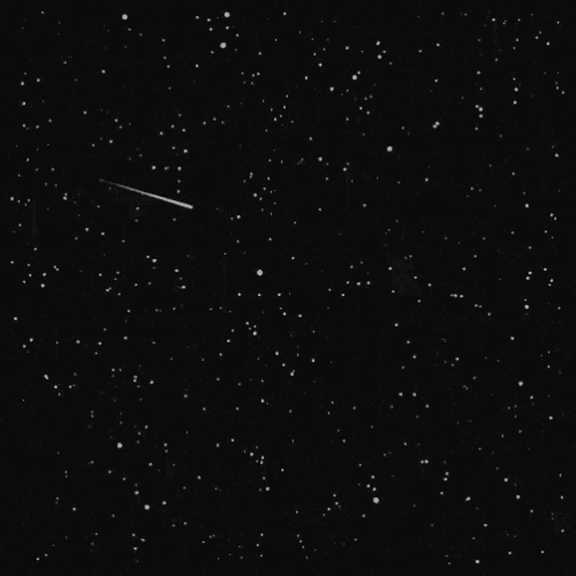 a shooting star is flying through a starry sky