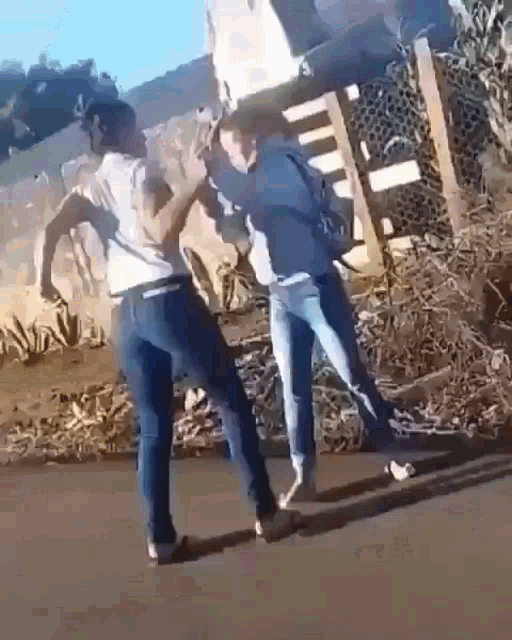 two people are standing next to each other on the side of a road .