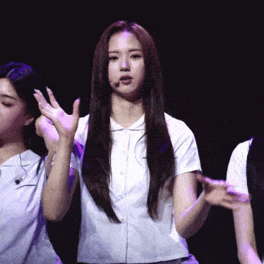 a girl with long hair is wearing a white shirt and a microphone