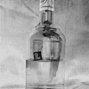 a black and white photo of a bottle of alcohol with the letter l on it