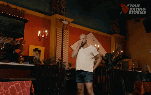 a man in a white shirt and shorts is standing in a room with the words true dating stories above him