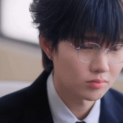 a close up of a person 's face wearing glasses
