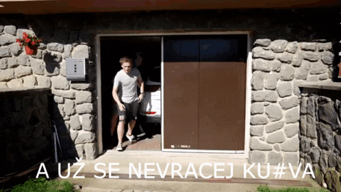 a man walking out of a garage with the words a uz se nevracej ku # va written below him