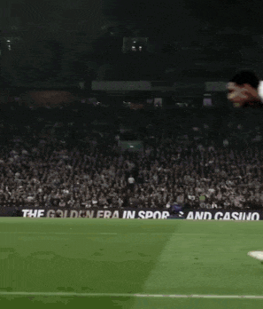 a soccer player is jumping in the air on a field with a banner that says the golden era in spor