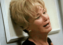 a woman is leaning against a wall and crying with her mouth open