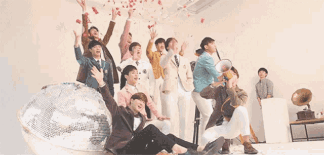 a group of people are posing for a picture with a disco ball