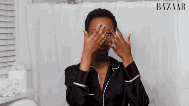 a woman covering her eyes with her hands in front of a shower curtain that says bazar