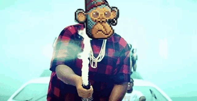 a man in a plaid shirt is holding a sword with a monkey face on his face .