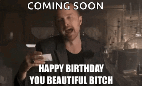 a man in a suit is holding a piece of paper that says coming soon happy birthday you beautiful bitch