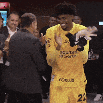 a soccer player wearing a yellow jersey that says foxlux