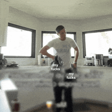 a man standing in a kitchen wearing a palm public shirt