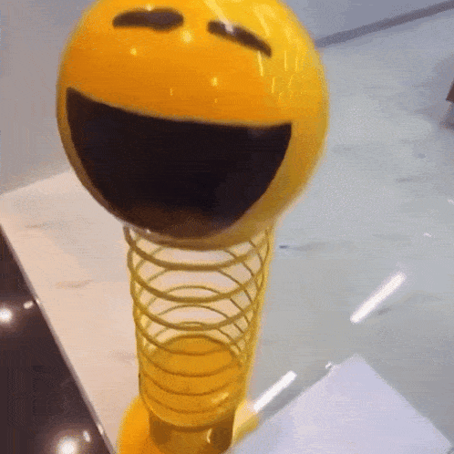 a yellow smiley face on a spring toy