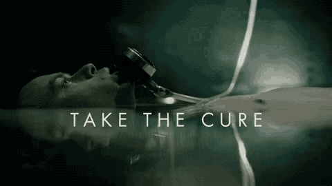 a man laying in a body of water with the words take the cure