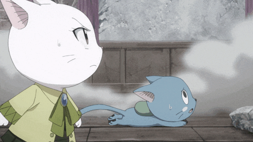 a white cat standing next to a blue cat laying down