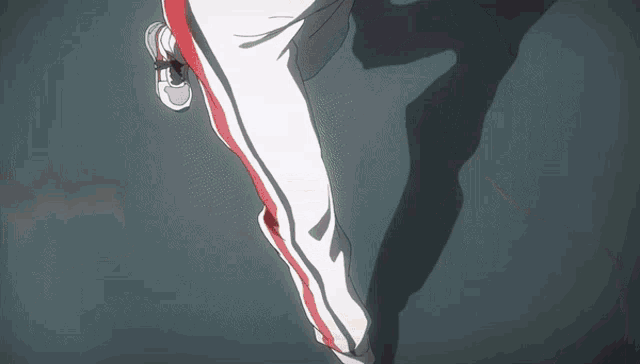 a person in red and white pants is running on a dark floor