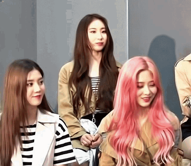 a girl with pink hair is standing next to another girl