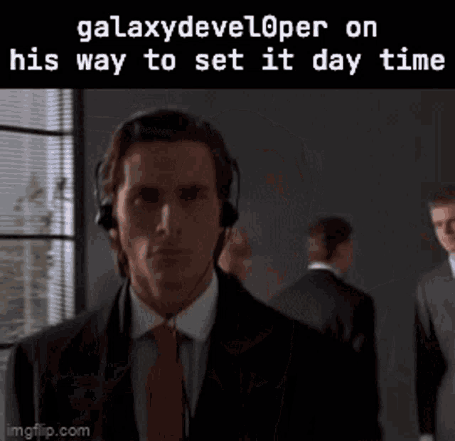 a man in a suit and tie is wearing headphones and a caption that says galaxydeveloper on his way to set it day time