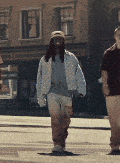 a man wearing a hat is crossing a street