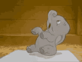 a cartoon elephant is sitting on a table with its eyes closed