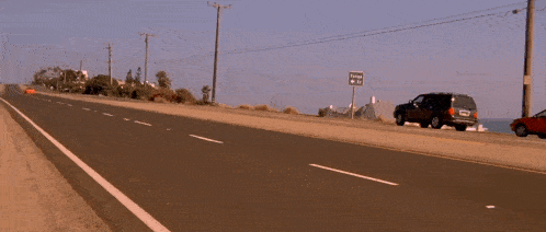 a red sports car is driving down a road