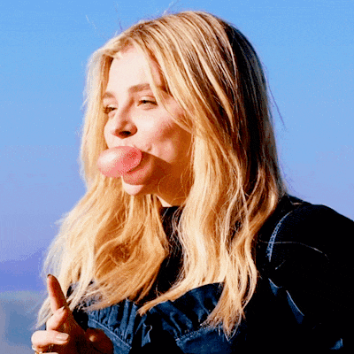 a woman blowing a bubble with her tongue