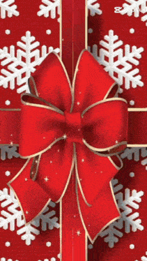 a red christmas present with a bow and snowflakes
