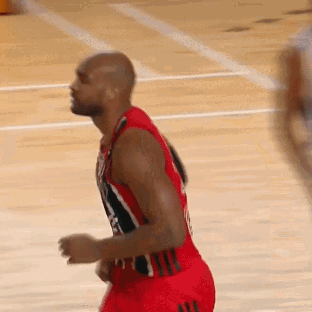 a basketball player wearing a red and black jersey with the number 11 on it