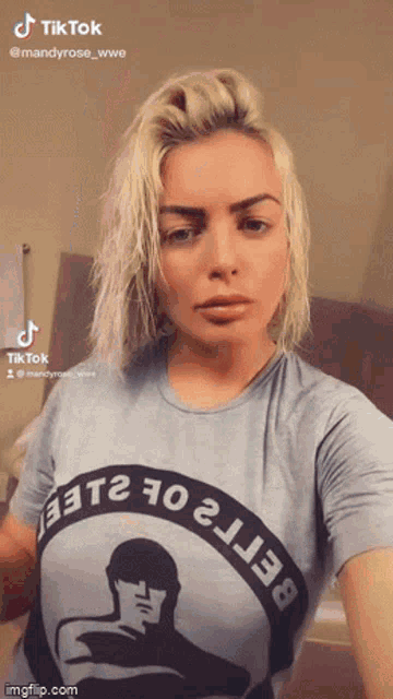 a woman with blonde hair is wearing a t-shirt with a man on it .