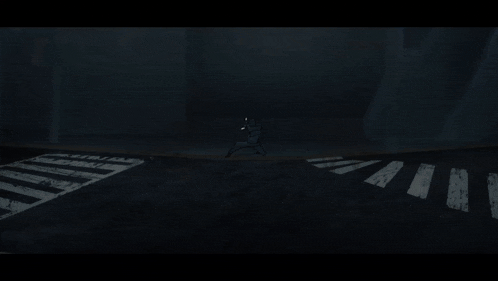 a person walking across a street at night