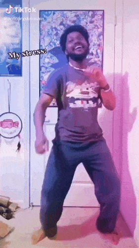 a man with a beard is dancing in a room with a purple wall .