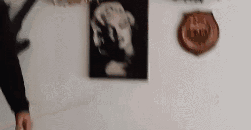 a man is standing in front of a wall with a painting of a dog on it .