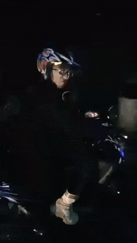 a man is riding a motorcycle in a dark room with a blurred background .