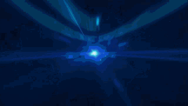 a blurred image of a tunnel with a blue light coming out of the end