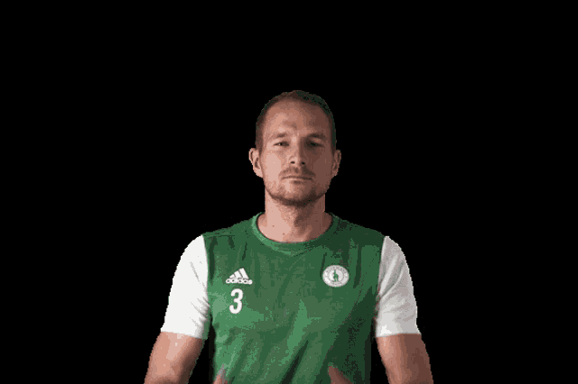 a man wearing a green adidas shirt crosses his hands