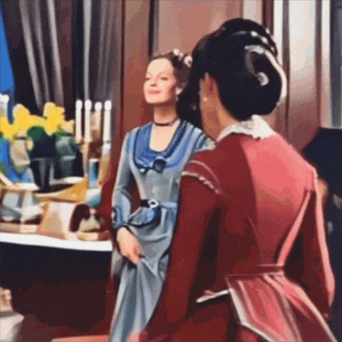 a woman in a blue dress and a woman in a red dress are standing next to each other