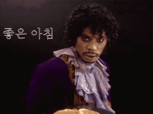 a man in a purple jacket is holding a plate of pancakes in his hand