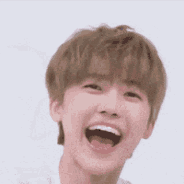 a young man is laughing with his mouth open