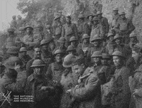 a black and white photo of a group of soldiers standing next to each other in a field .