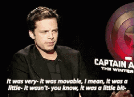a man in a suit is sitting in front of a sign that says captain america the winter soldier