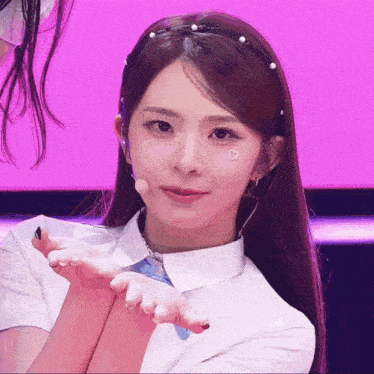 a girl wearing a headband with pearls on it looks at the camera
