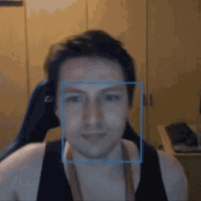 a man with a blue square around his face looks at the camera