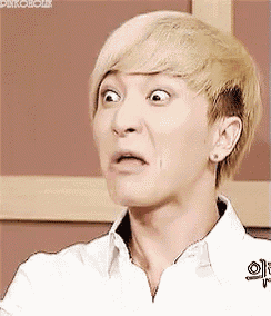 a young man with blonde hair is making a funny face .