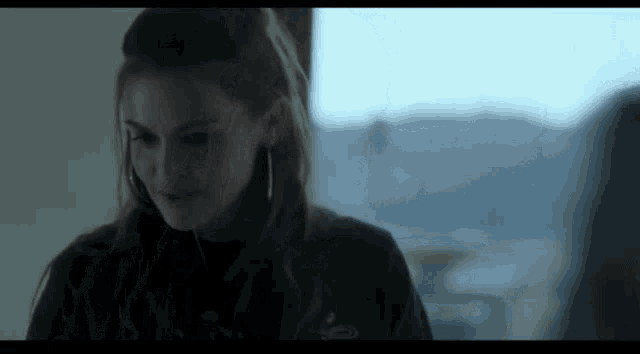 a woman is standing in front of a window in a room .