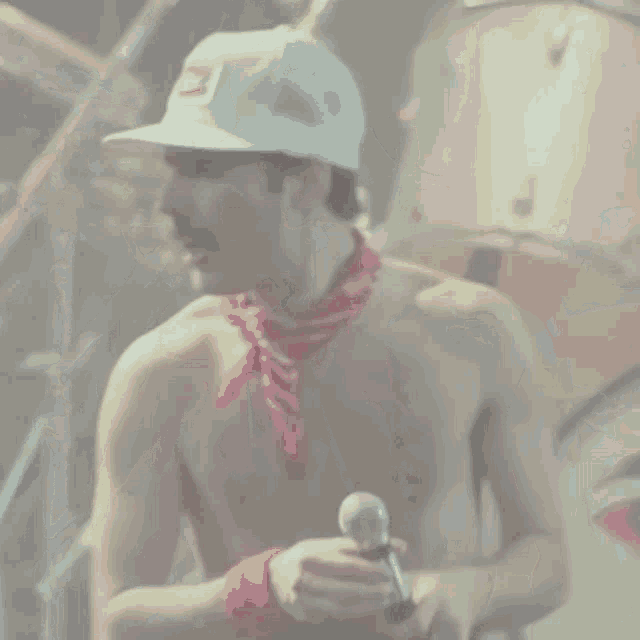 a shirtless man is singing into a microphone while wearing a hat that says canadiens on it