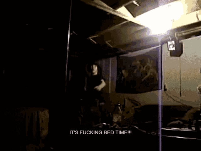 a dark room with the words it 's fucking bed time on the bottom