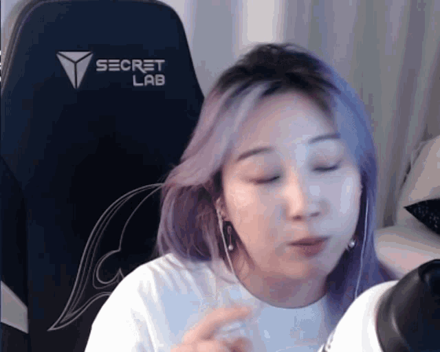 a woman with purple hair is sitting in a secret lab chair